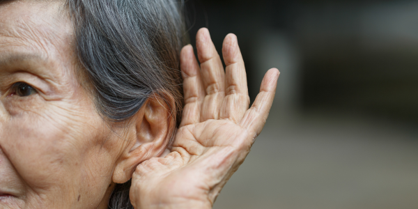 Mujer que ahueca la oreja para escuchar mejor